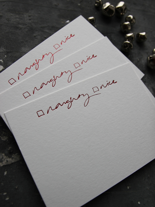 Christmas notecard from Santa that has a tick box for Naughty or Nice in red foil with an envelope that says North Pole Mail