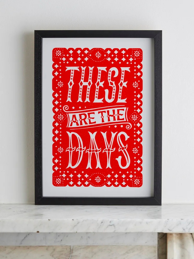 these are the days linocut. a linocut phrase printed on red paint.