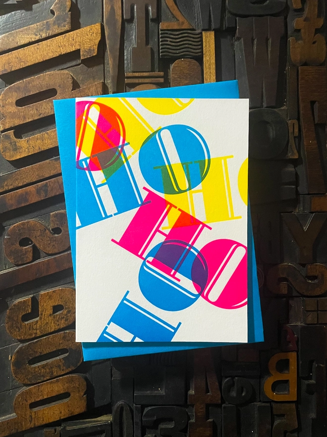 Ho Ho Ho! A beautiful typographic letterpress Christmas card. Printed with rich vibrant and fluorescent blue, magenta and yellow inks with luxury matching and contrasting envelopes; ideal to send to your designer friends at the festive season.