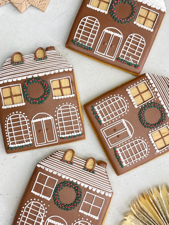 Hand-iced Christmas gingerbread house biscuit, individually wrapped for festive gifting.
