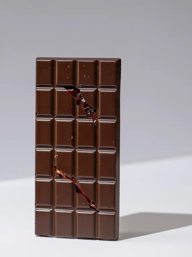Red chilli chocolate tablette standing on a white table. 