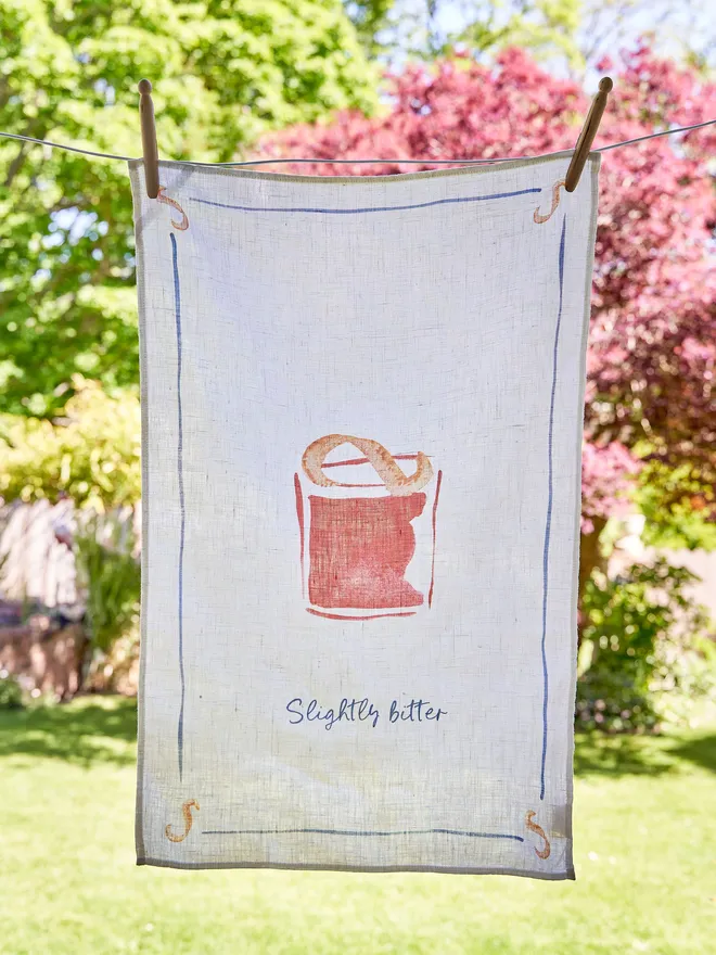 Negroni - Slightly Bitter Linen Tea Towel, hanging on the washing line in the garden 
