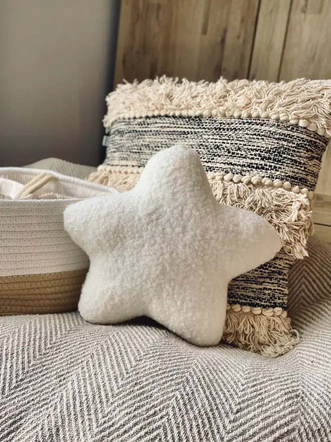 boucle star pillow. a star shaped pillow cushion on a sofa.