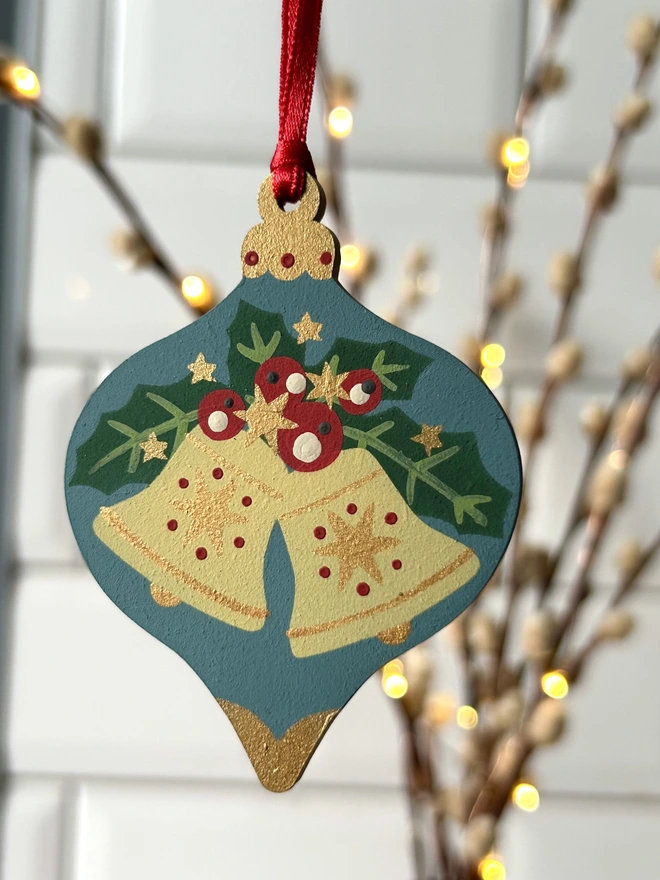 Laser cut wooden bauble shapes which have been hand painted with one christmas candle design and one with a festive bell design. Using blue, yellow, green, red and gold paint.