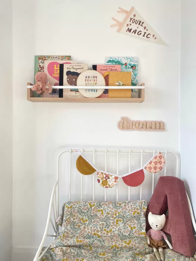 Large bookshelf by Autumn's Corner seen above a bed with 'Dream' sign made in wood.