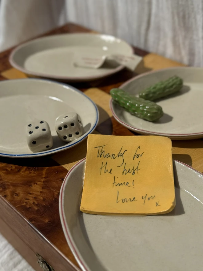 Still Life Trinket, a collection of trinkets sitting on a plate on a wooden surface.  Dish