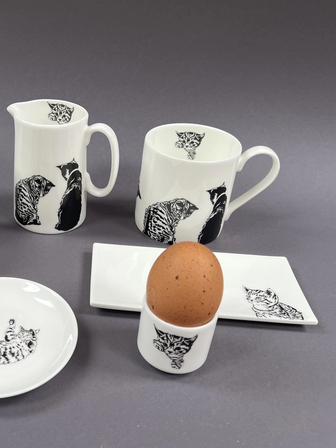 Close up of the egg cup with egg n it, Mug, half jug and rectangle trinket tray