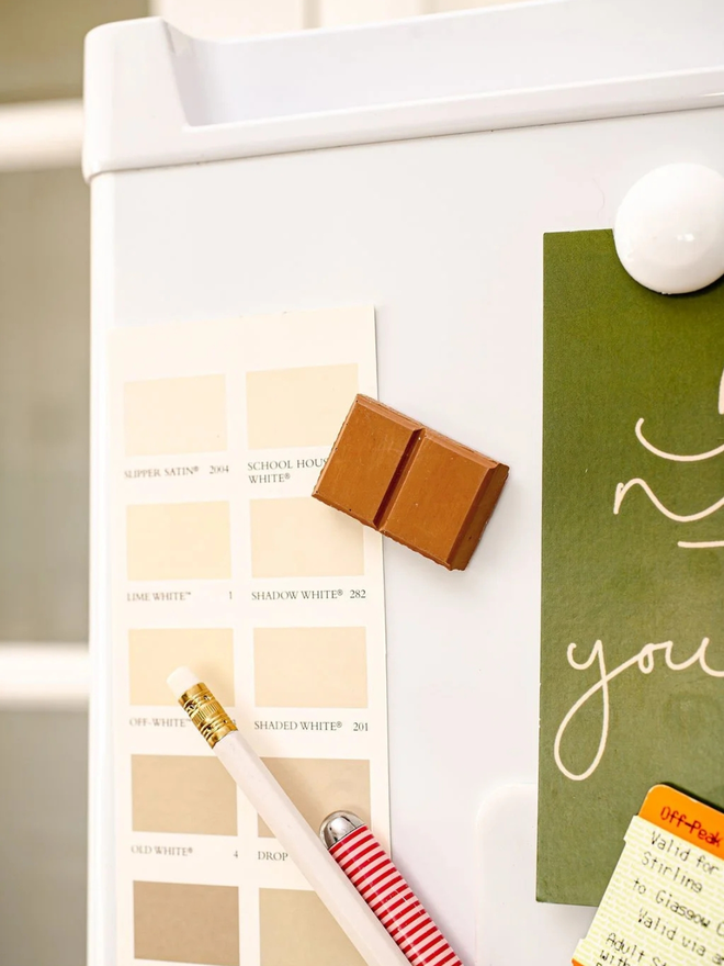 ceramic chocolate magets. a milk chocolate magnet on a fridge door.