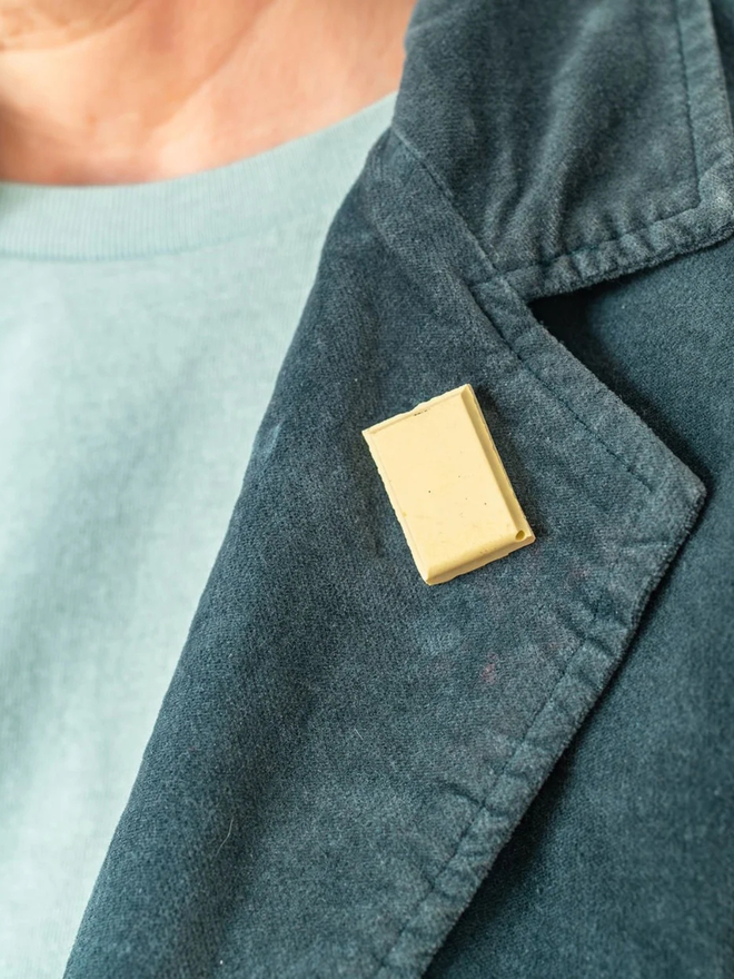 chocolate pin badges. a white chocolate badge on a coat lapel.