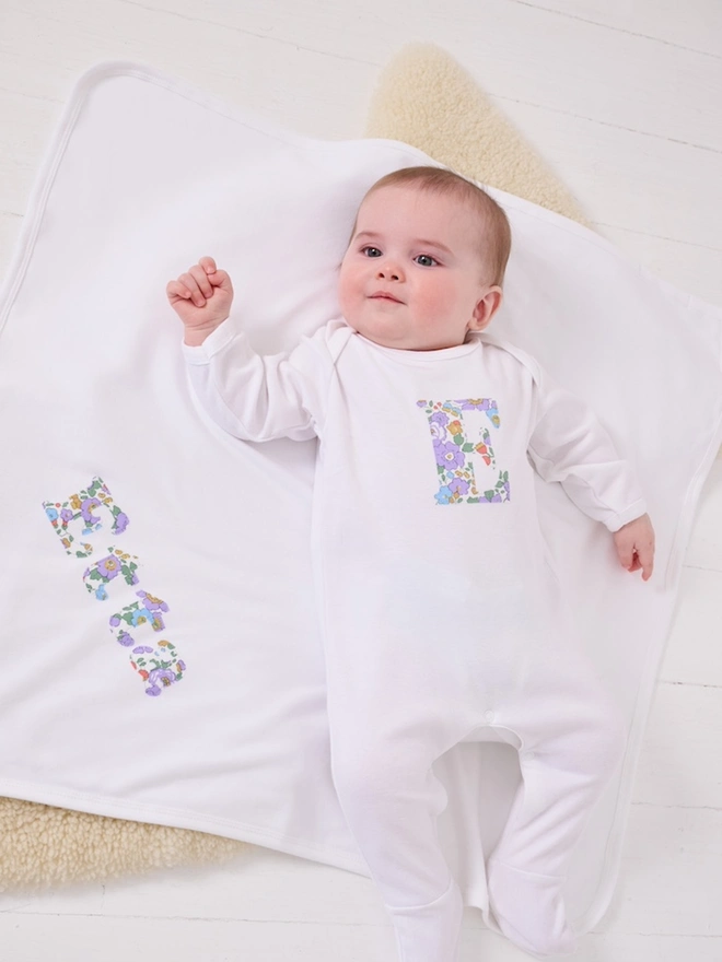 A soft cotton new baby blanket with a name appliquéd on in Betsy Liberty print.