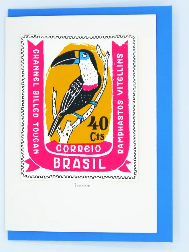 Bird Stamp Card Brazil Toucan, a white card with a toucan stamp against a plain background with a blue envelope. 