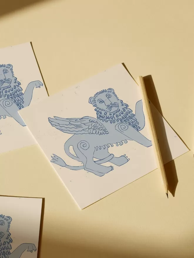 Annika Reed Studio blue winged lion woodblock print seen on a card.