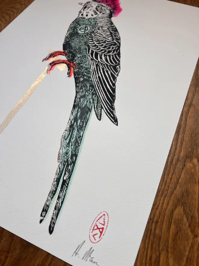 Punk budgie lino print, with symbols, coloured with blue and pink paint with on a white background. 