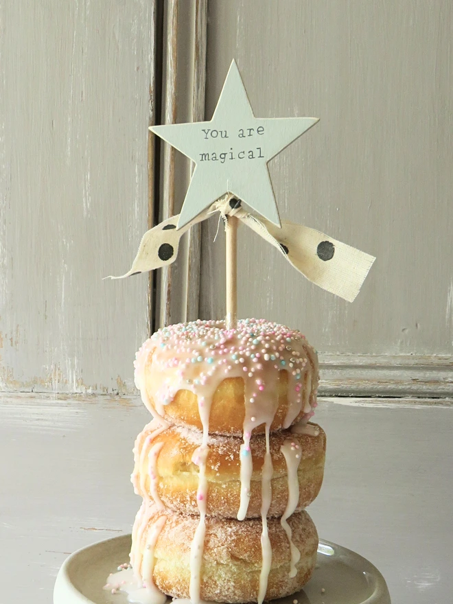 wooden star shaped cake topper with hand painted message and ribbon detail