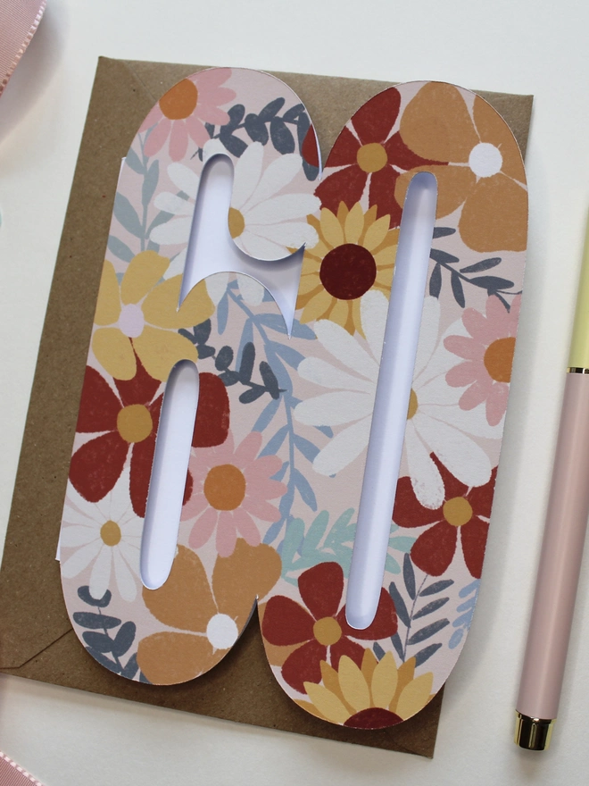 floral 60th birthday card. card shaped like 60 adorned with illustrated flowers.