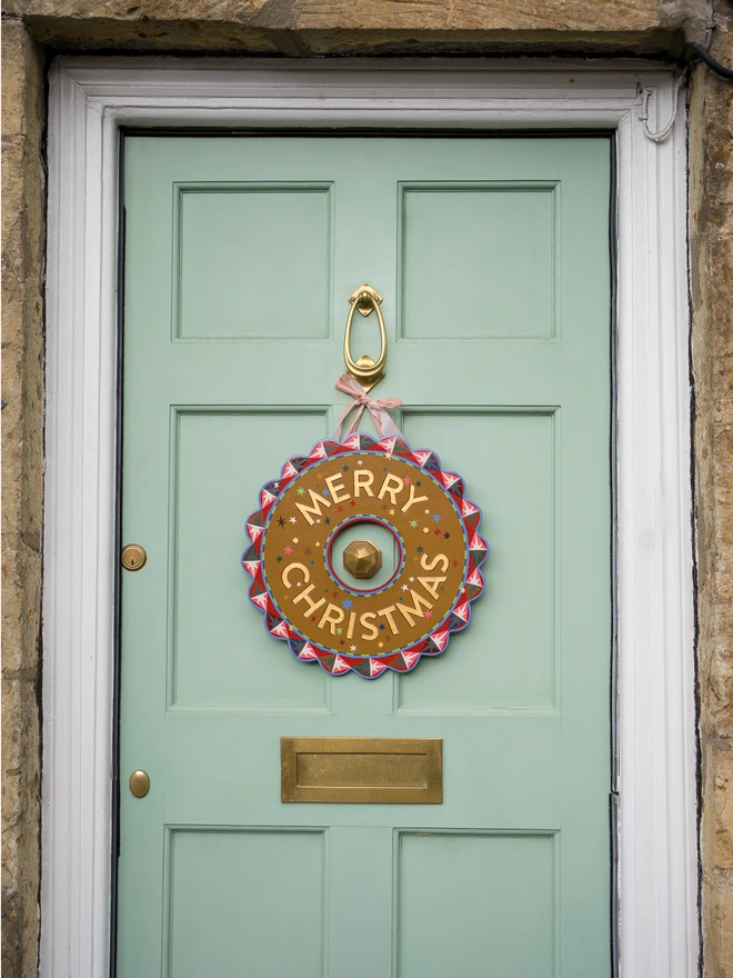 Multicoloured Hand painted Christmas Wreath with gold leaf lettering on a pale green front door