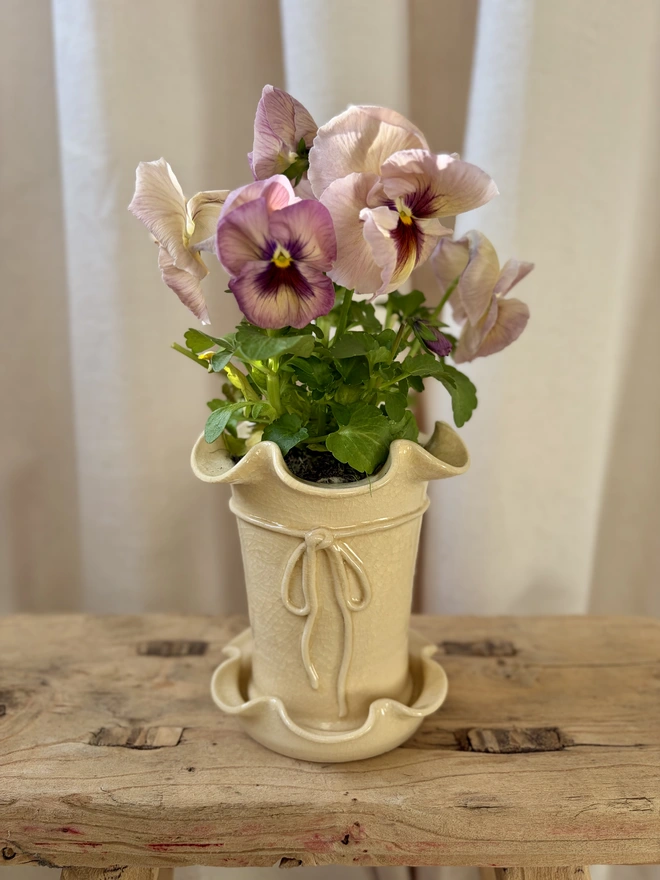 Frilly ceramic plant pot with saucer and bow in butter yellow crackle glaze