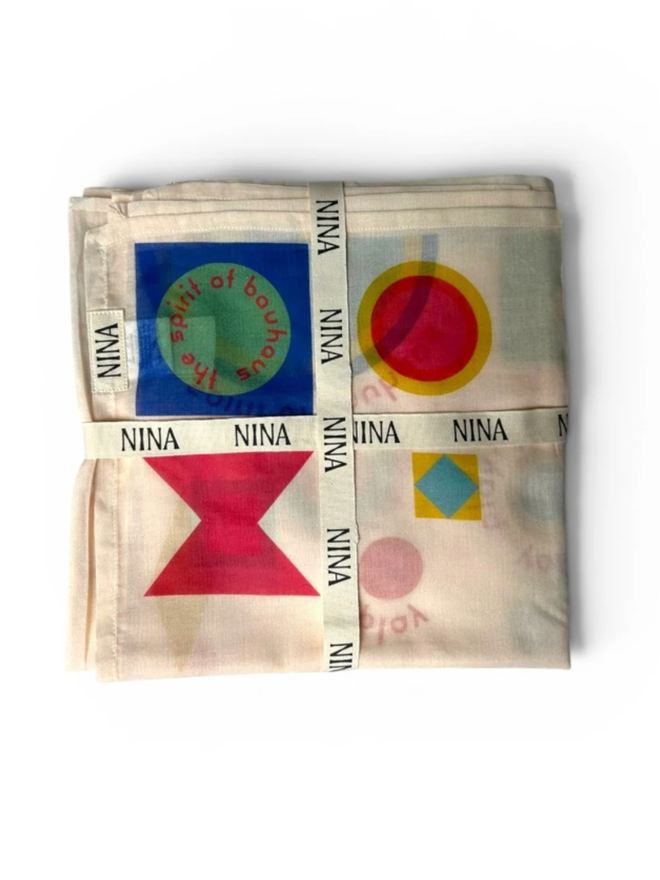 Bauhaus Play Muslin. A muslin with geometric pattern, folded and wrapped.
