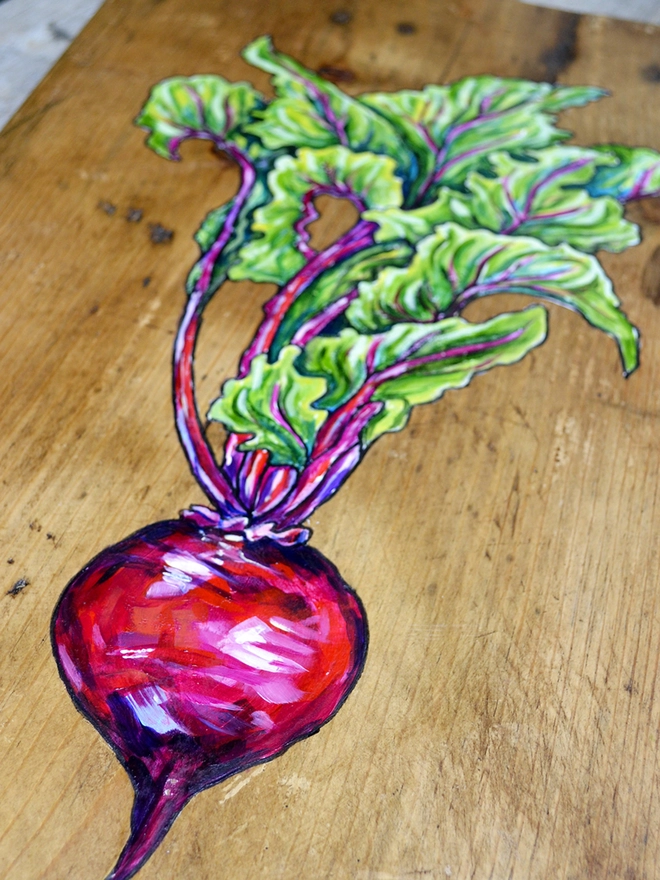 Detail of a beetroot design on a wooden serving board