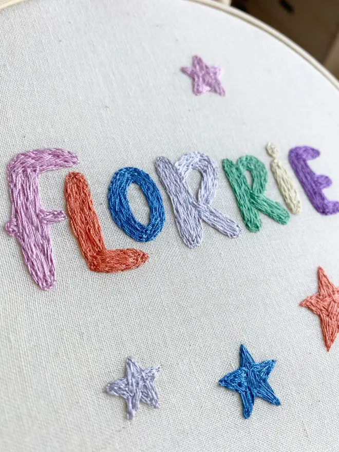 custom embroidered hoop. cotton hoop embroidered with multi coloured lettering.