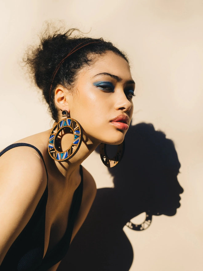 A woman wearing Intricate Hoop Earrings.