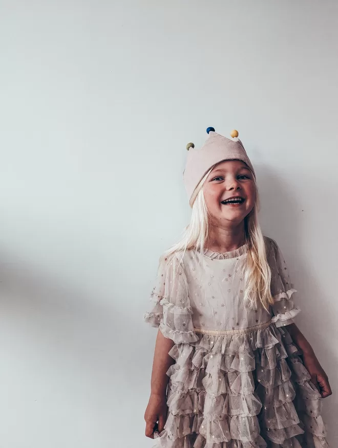 Girl wearing crown with pom poms