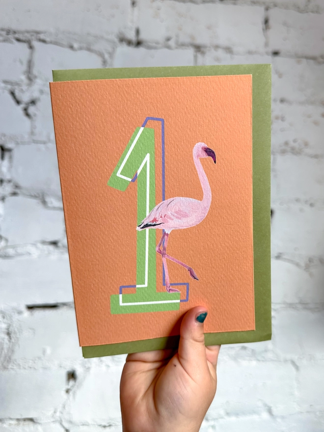 an orange card with a big green number 1 and a flamingo illustration with a green envelope