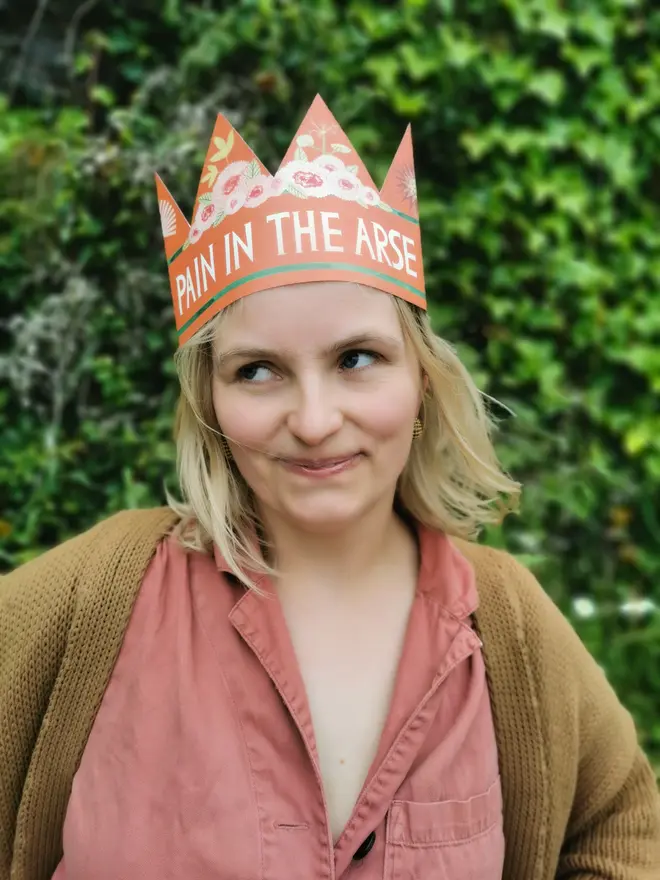 red crown shaped card with flowers and 'pain in the arse' text