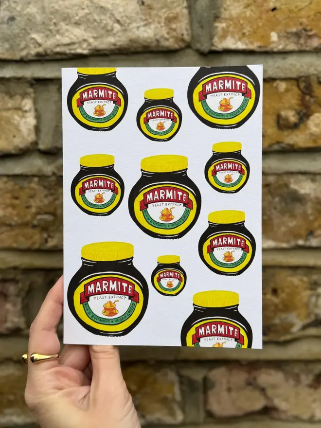 marmite jars illustrated card. card photographed against brick wall backdrop.