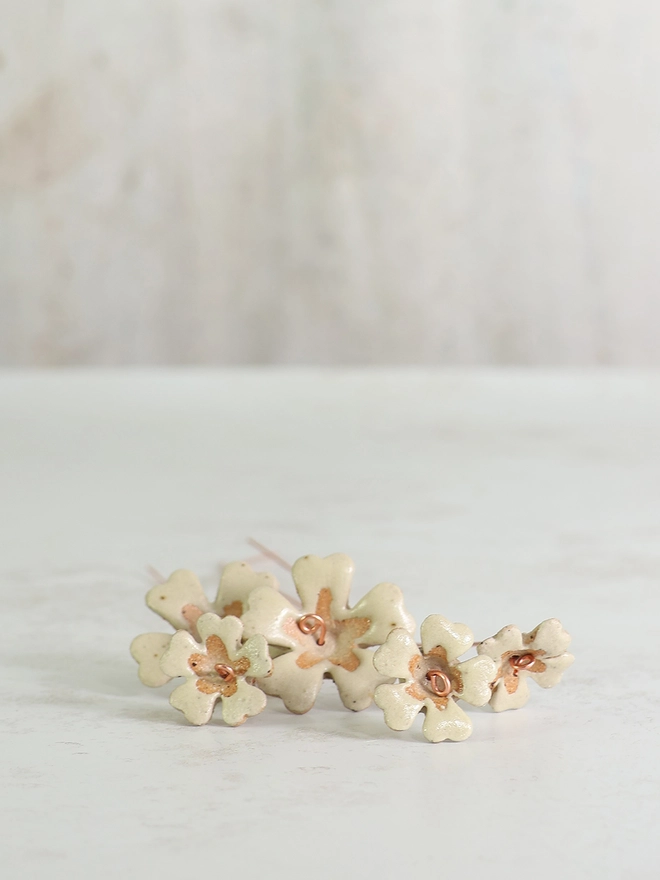 yellow ceramic flowers lay flat on a white table top 