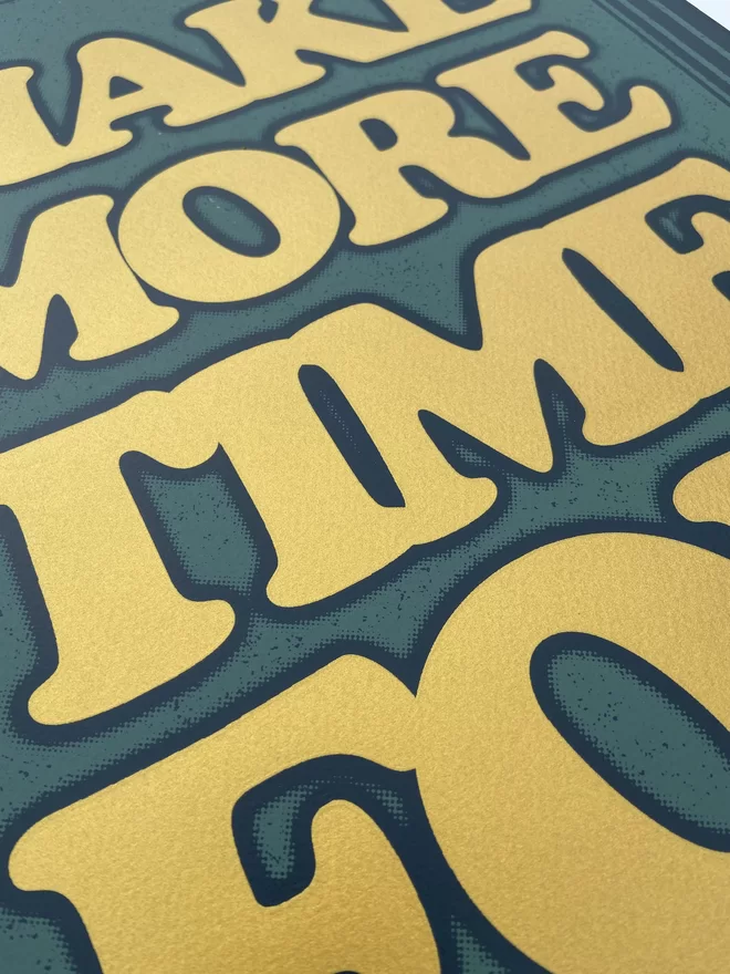 green leather looking screen print with gold letters that says “make more time for friends”