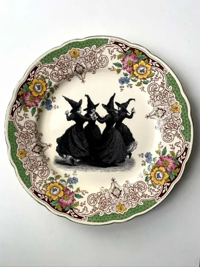a vintage plate with an ornate floral border in the centre is a witch's coven