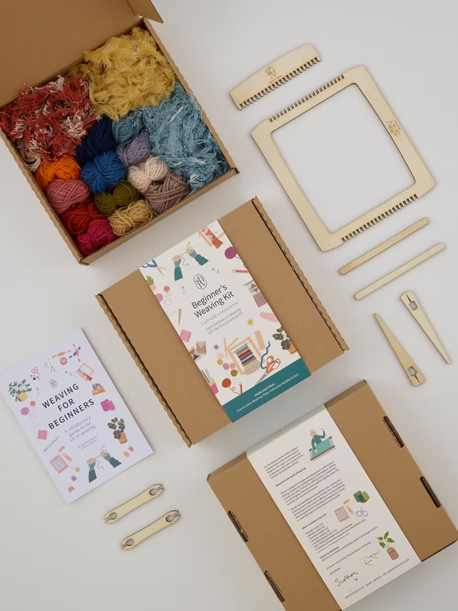 beginners' weaving kit. a wooden weaving kit and colourful yarn displayed on a white backdrop.