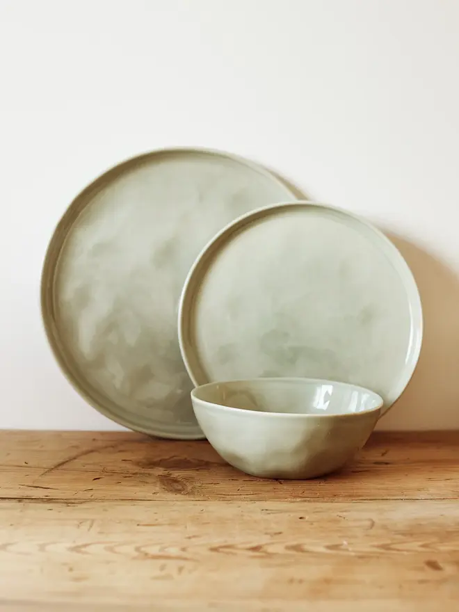 stoneware place setting dining set. a green set of stoneware plates and bowls.