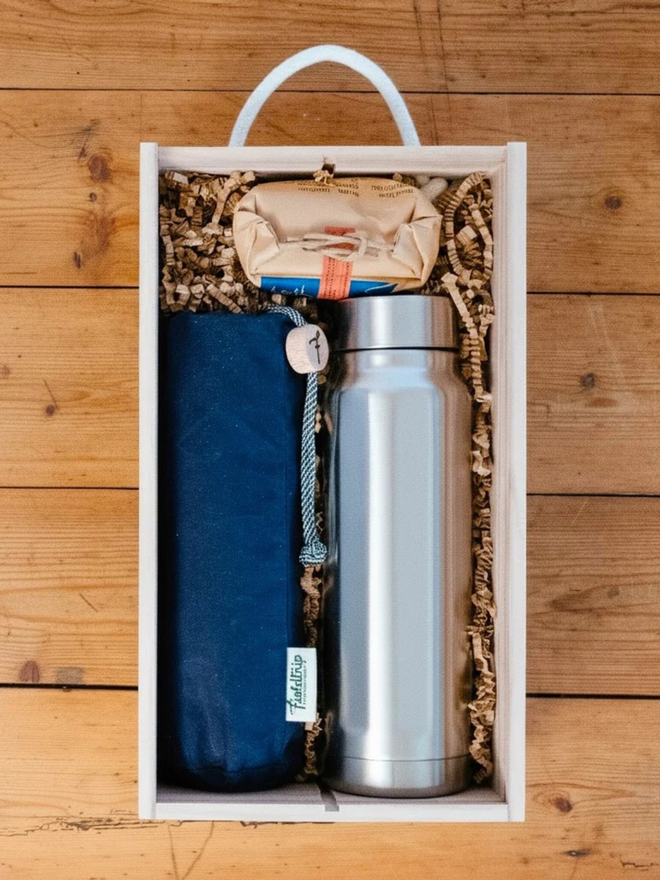 land rover cups and flask gift set. a wooden box containing 5 stainless steel cups in a  navy blue cloth bag, a box of hot chocolate and a stainless steel flask.
