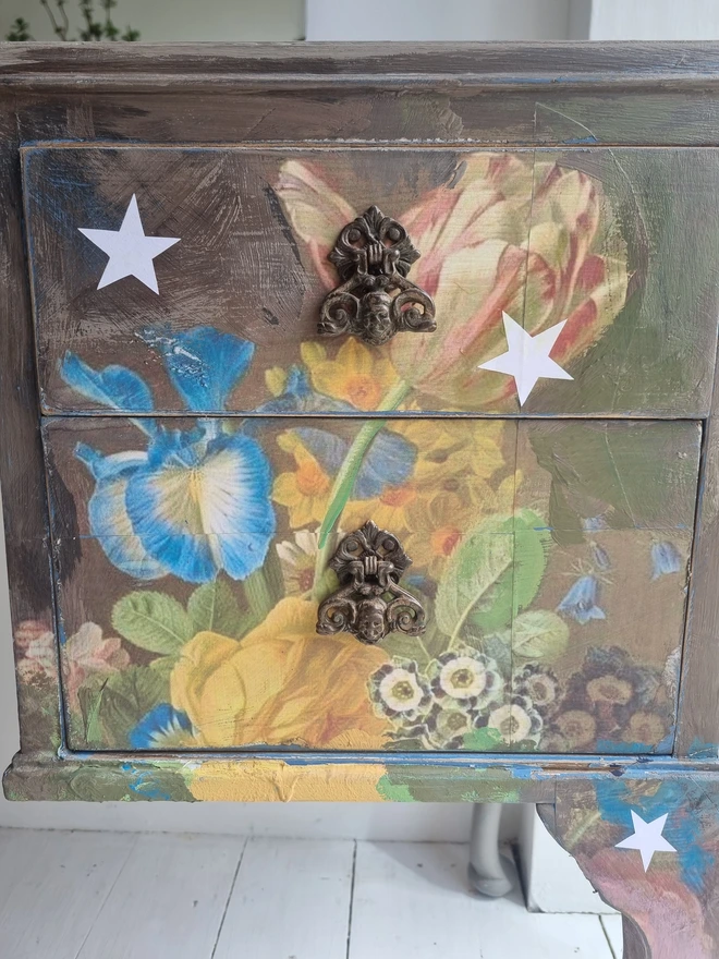 Vintage painted dressing table and chair. Painted in coffee grey and decorated using layered antique florals with yellow and blue accents and finished with hand-cut white paper stars. Text reads in blue 'think happy thoughts'. Heavily distressed finish.