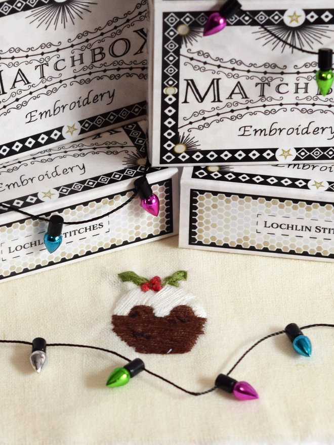 A Classic Christmas Pudding embroidery.  Surrounded by matchboxes and mini bauble trims.