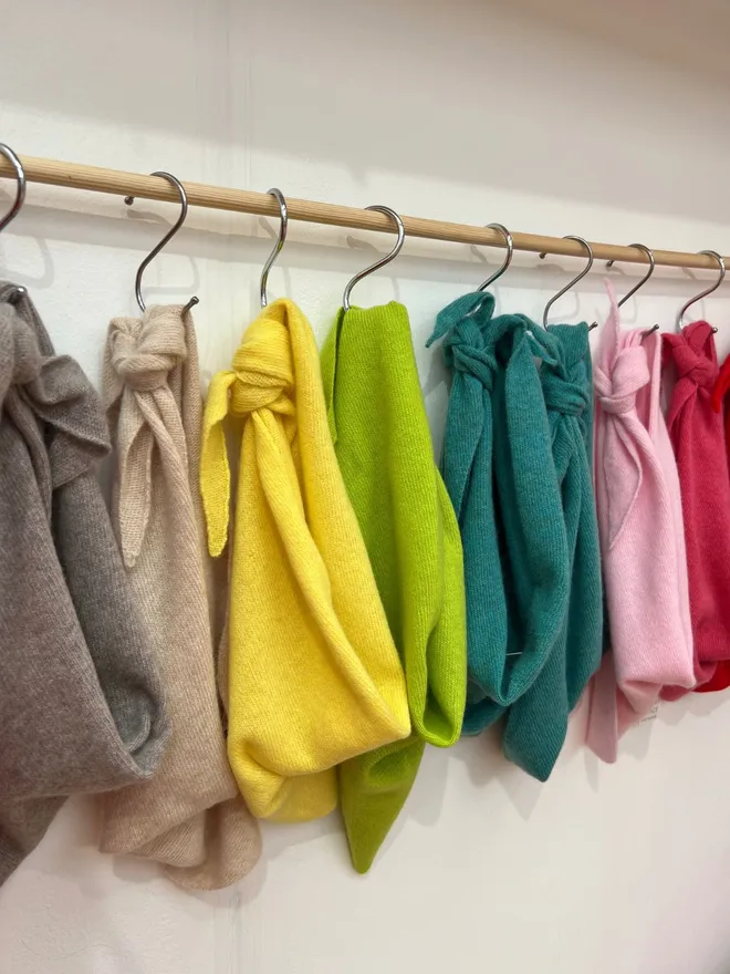 Colourful Triangle Scarves Shown Hanging on Rail