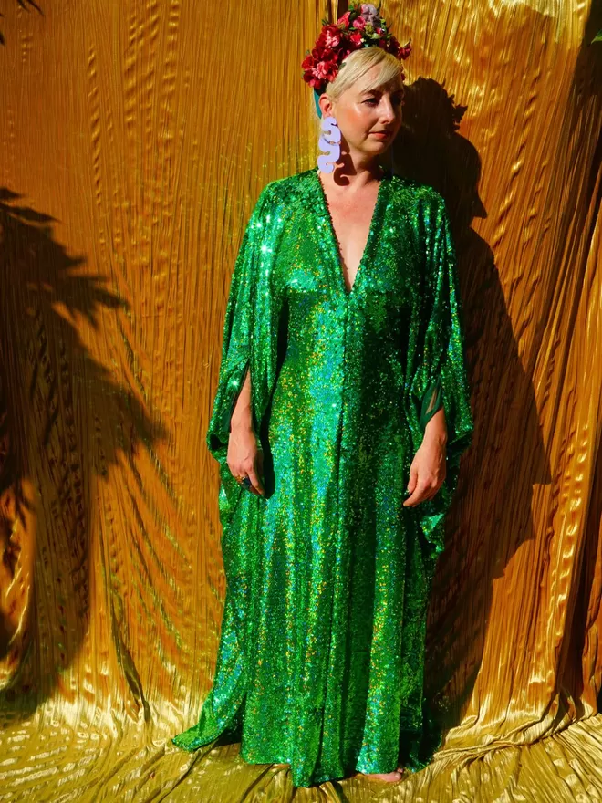 Fumbalina Green Sequin Kaftan seen worn by a woman with her hands by her side.
