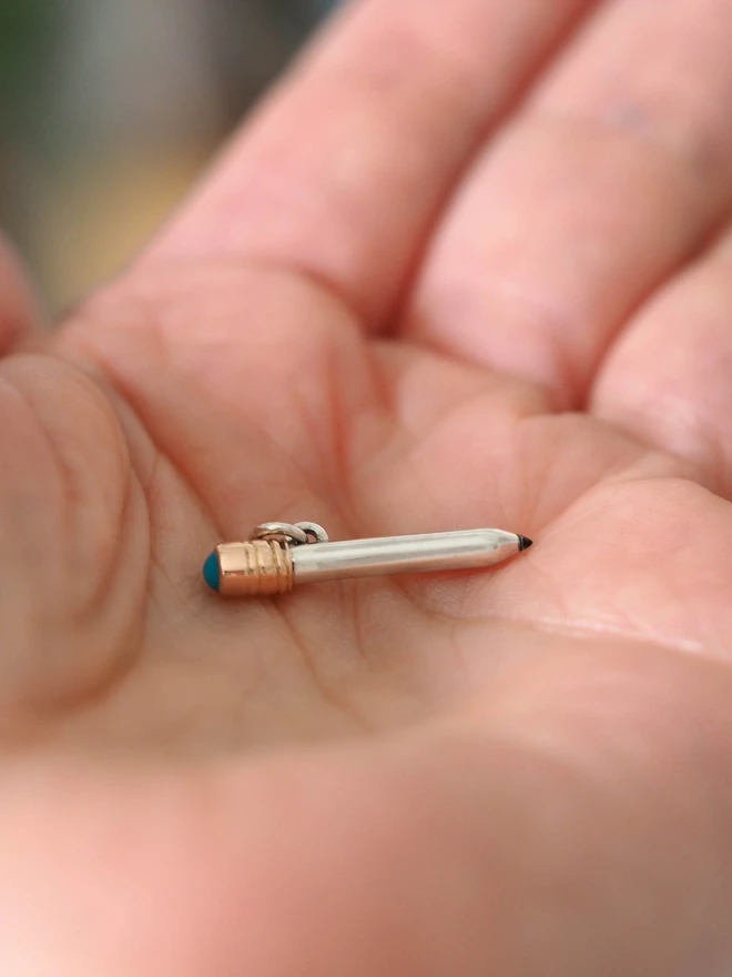 Turquoise dinky pencil charm on a hand
