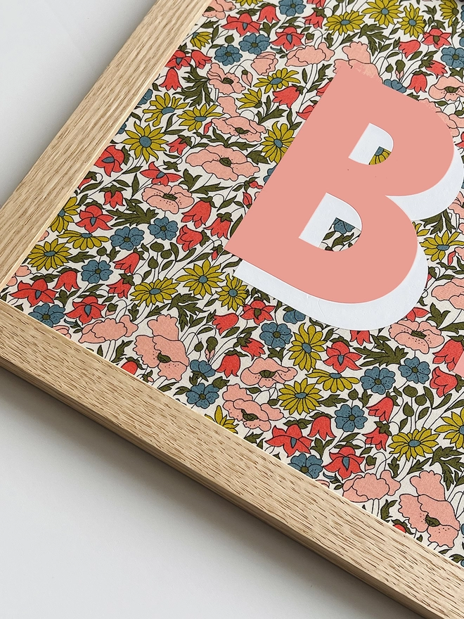 Personalised framed word/name picture in salmon pink with white highlights on Liberty Poppy & Daisy fabric - close up