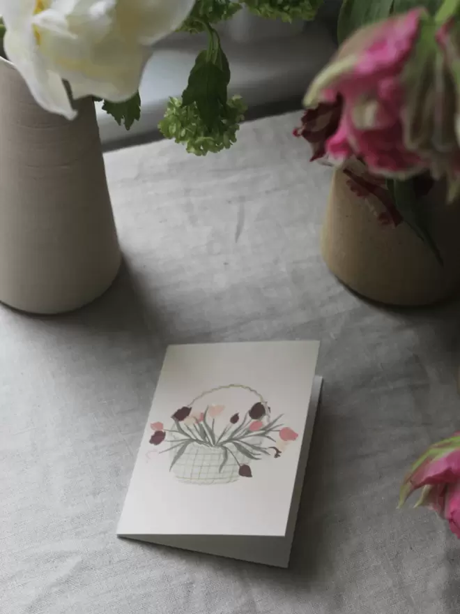 basket of tulips on a greetings card surrounded by tulips