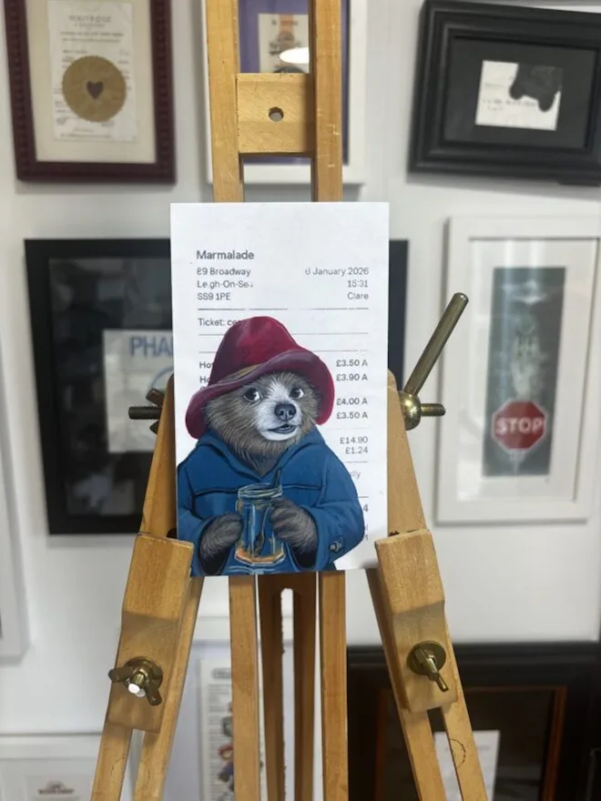 Out Of Marmalade Paddington Print, in a wooden stand.