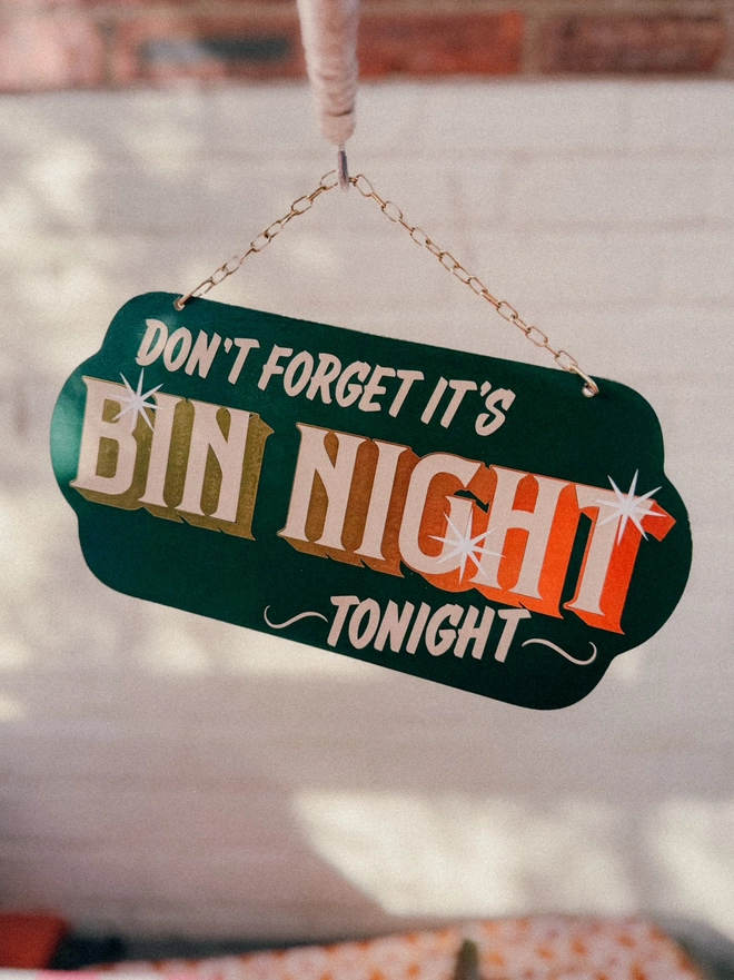 green 'dont forget it's bin night tonight' sign with gold text and hanging chain