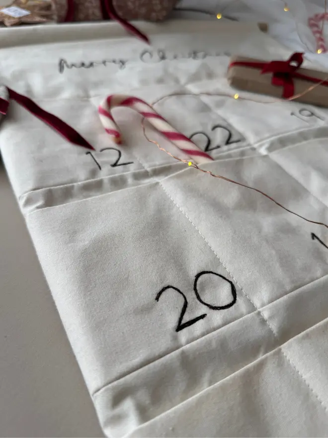 Embroidered Advent calendar. Close up pockets with stitched numbers and fabric 