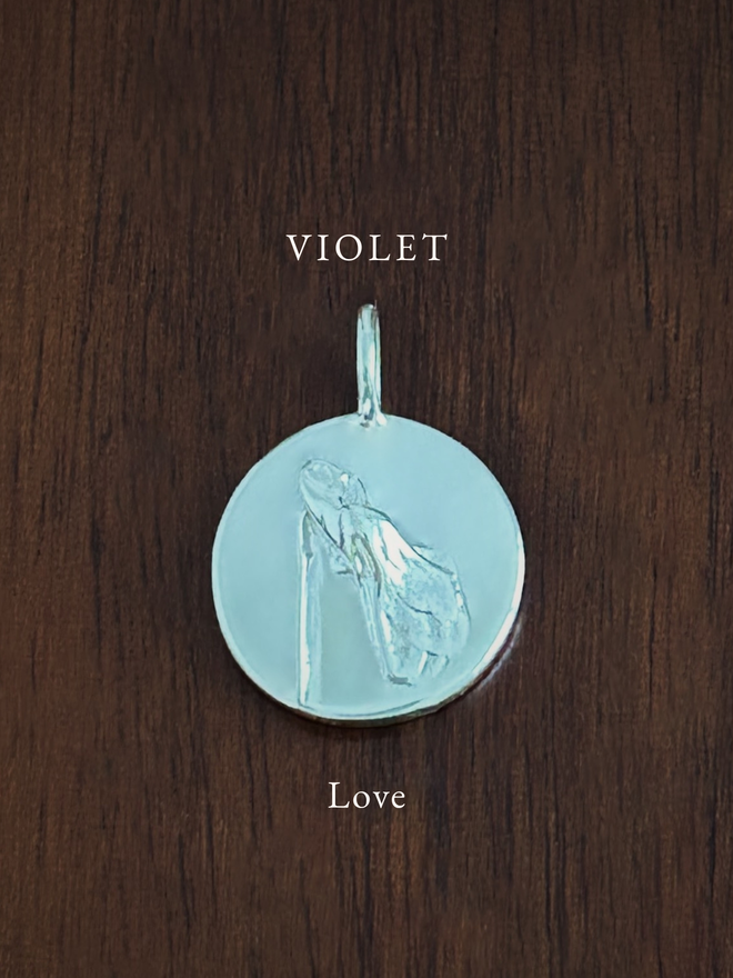 Sterling Silver Violet Coin Charm on a dark background with the language of flowers meaning, love