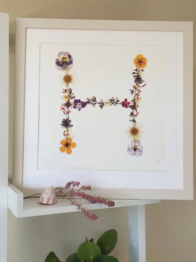 Pressed Wildflower Letter Print, a wildflower alphabet letter print sitting framed. 