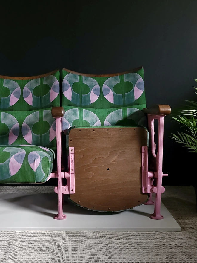 Vintage cinema seats in green and pink Boucle velvet with black wall background