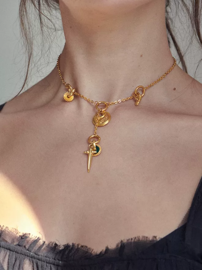 Woman wearing gold necklaces with charms and pendants