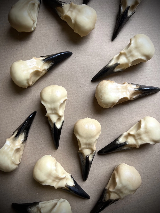 Realistic edible white chocolate crow skulls on brown paper